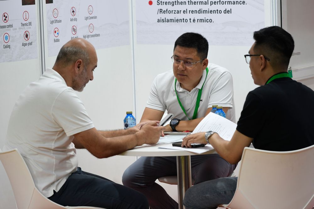 Reunión de negocios entre expositores chinos y un visitante profesional, durante la celebración de Infoagro Exhibition 2025