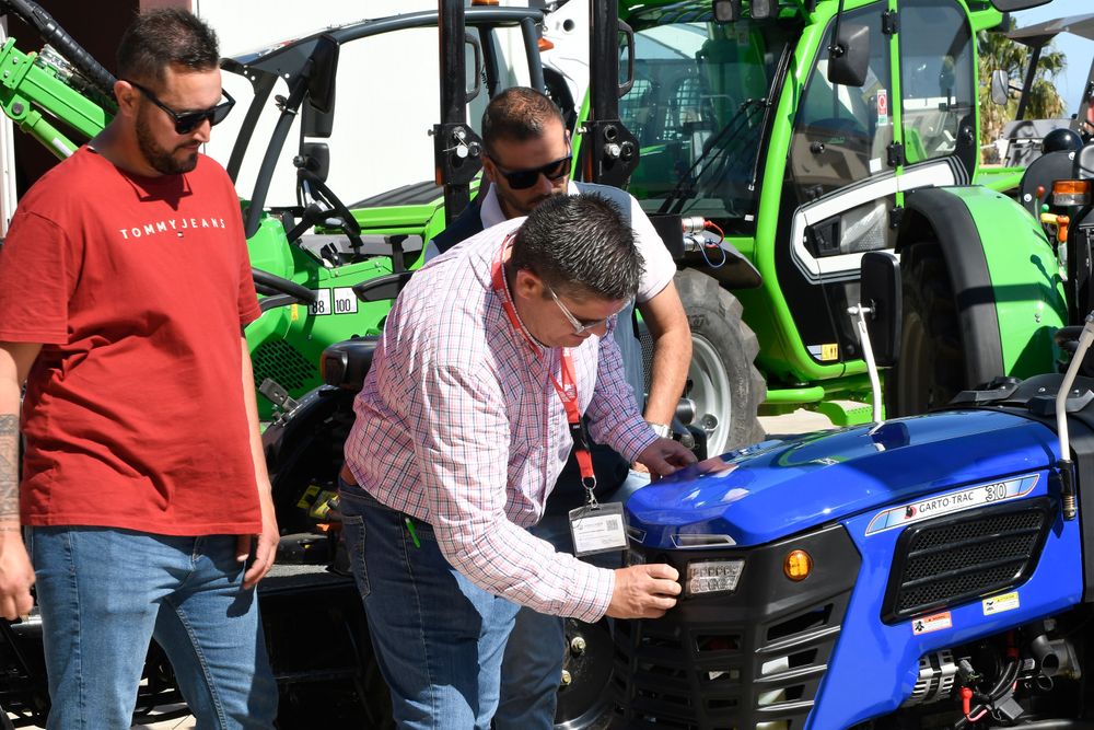 Visitantes profesionales consultan a un expositor sobre uno de sus tractores, en Infoagro Exhibition 2025
