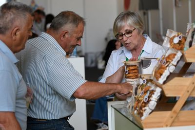 Una empresa expositora muestra a visitantes profesionales los detalles de uno de sus productos