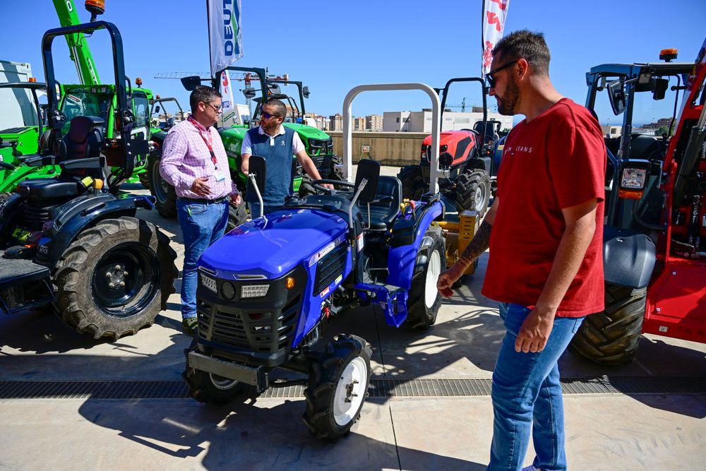 Expositor, explicando las características de una máquina a un visitante profesional a Infoagro Exhibition 2025